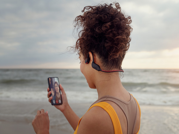 Woman enjoying crystal call feature of Philips bone-conducting headphones